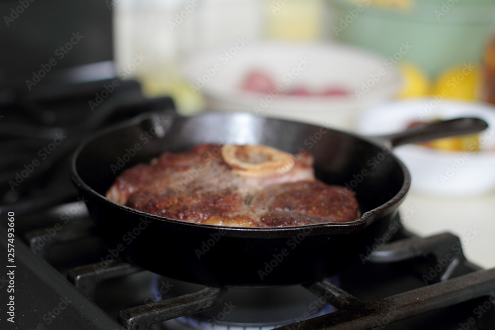 Shank steak frying in a cast iron pan. Shank steak frying in a cast iron pan.
