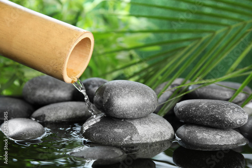 Traditional bamboo fountain with zen stones. Space for text