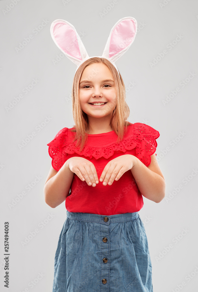 easter, holidays and childhood concept - happy girl wearing bunny ears headband over grey background easter, holidays and childhood concept - happy girl wearing bunny ears headband over grey background