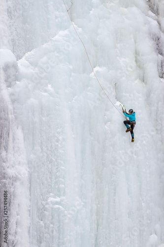 A  woman ice climbs on Blodgett Falls in the Bitterroot Mountains of Montana. photo