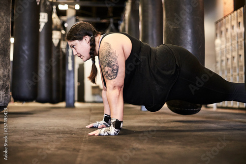 A woman doing push-ups at a boxing gym photo