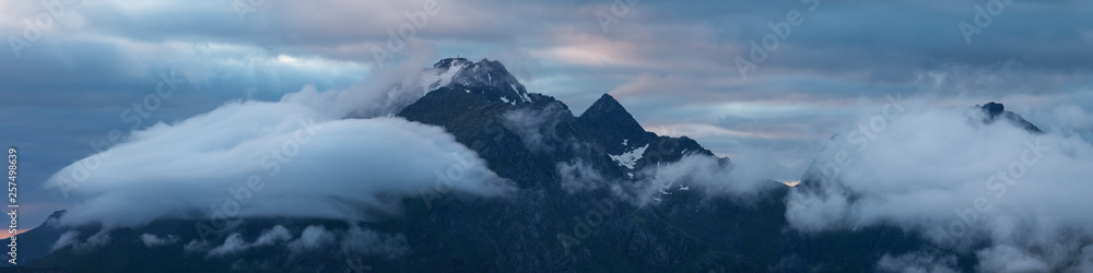 Himmeltindan mountain peaks behind clouds, Vestvagoya, Lofoten Islands, Norway Himmeltindan mountain peaks behind clouds, Vestvagoya, Lofoten Islands, Norway