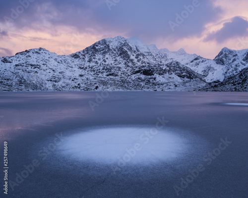 Himmeltindan mountain peak over frozen Vikvatnet, Norway photo