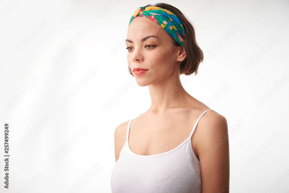 Half profile portrait shot of young woman standing at isolated white background and thinking Half profile portrait shot of young woman standing at isolated white background and thinking