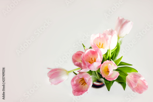 Wedding mockup with pink paper list and tulip flowers on blue table top view. Beautiful floral. Flat lay style.