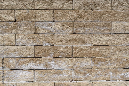 Background of yellow stone bricks displayed horizontally in a wall 