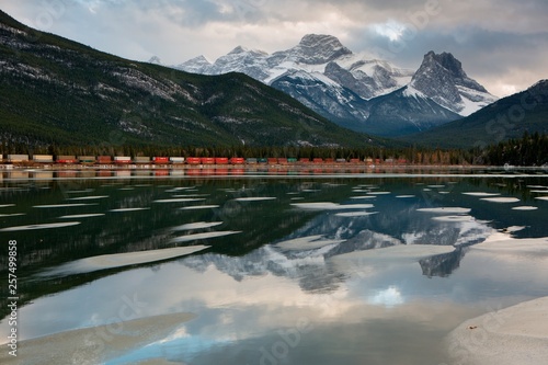 Mountains and train relected in lake photo