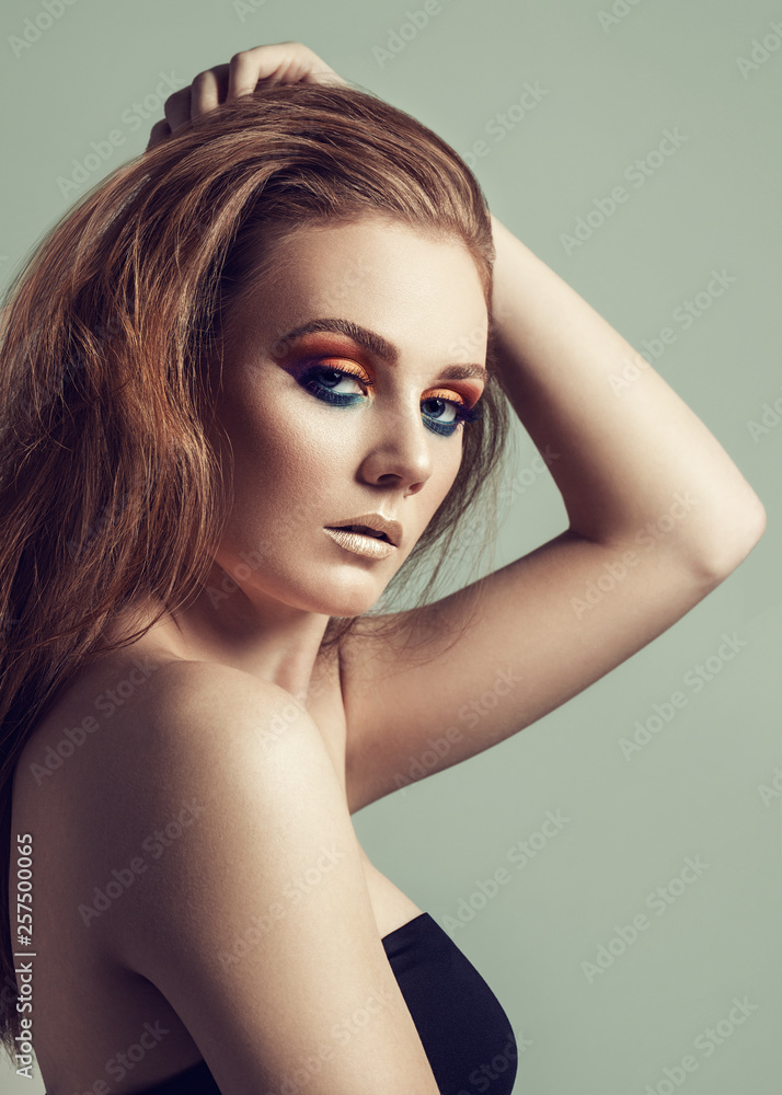 Naklejka premium Portrait of beautiful woman with holiday make up and long ginger hair.