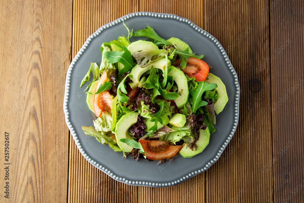 Healthy salad mix of iceberg, spinach, avocado and cucumber with olive oil, tomato and lemon. Top view. Healthy salad mix of iceberg, spinach, avocado and cucumber with olive oil, tomato and lemon. Top view.
