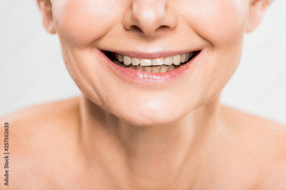 partial view of mature and smiling woman isolated on grey partial view of mature and smiling woman isolated on grey