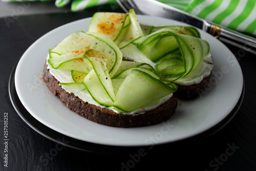 Cucumber sandwich. Healthy snack. Sandwich with cream cheese, cucumber, served on a plate. Symbolic image. Concept for a tasty and healthy meal. Close up.