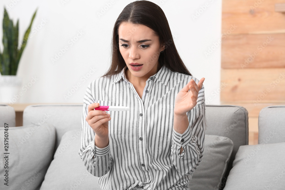 Young woman with pregnancy test at home. Gynecology and childbirth Young woman with pregnancy test at home. Gynecology and childbirth