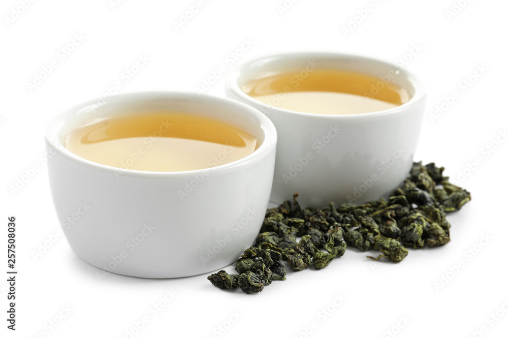 Cups of Tie Guan Yin oolong and tea leaves on white background Cups of Tie Guan Yin oolong and tea leaves on white background