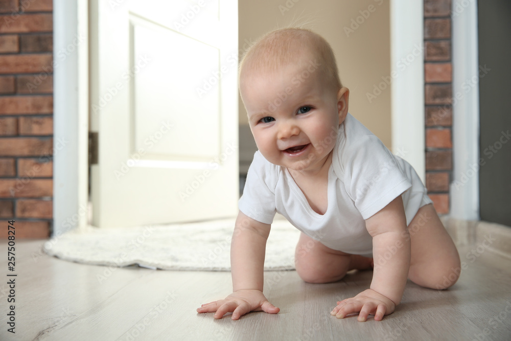 Cute little baby crawling on floor indoors, space for text Cute little baby crawling on floor indoors, space for text