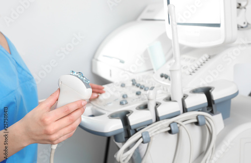 Professional sonographer using modern ultrasound machine in clinic  closeup