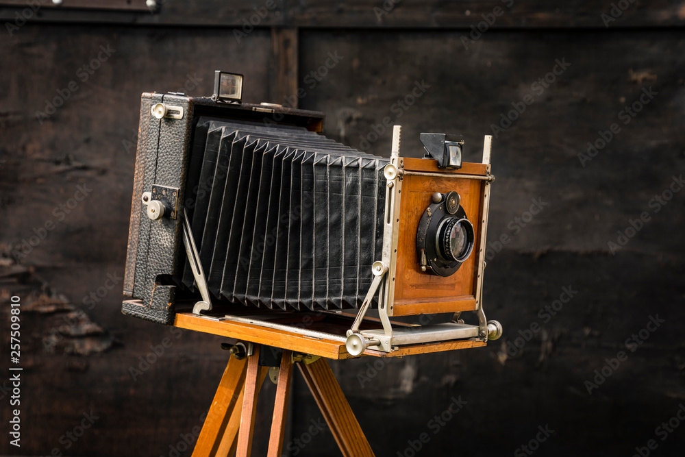 Fototapeta premium An old large format camera on a wooden tripod.