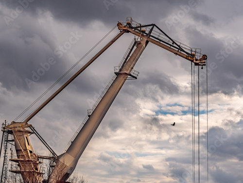 View of the big shipyard crane with scenic clouds in the background.