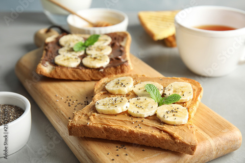 Tasty toasts with banana, mint and chia seeds on wooden board