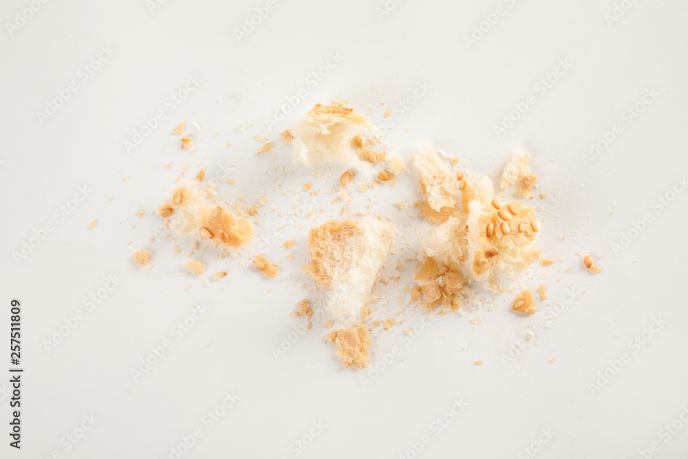 Scattered bread crumbs on white background, top view Scattered bread crumbs on white background, top view