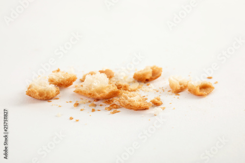 Scattered bread crumbs on white background, closeup photo