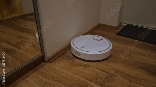 Robot vacuum cleaner cleans the hallway photo