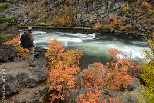 Man with backpack along Deschutes River at Dillon Falls in fall