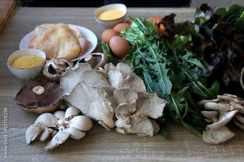 Various vegetables, mushrooms, chicken, eggs and grains on a wooden table. Selective focus.