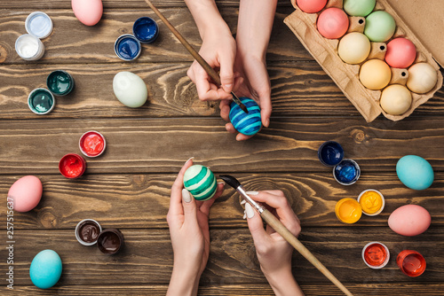 Photography top view of women painting easter eggs at wooden table
