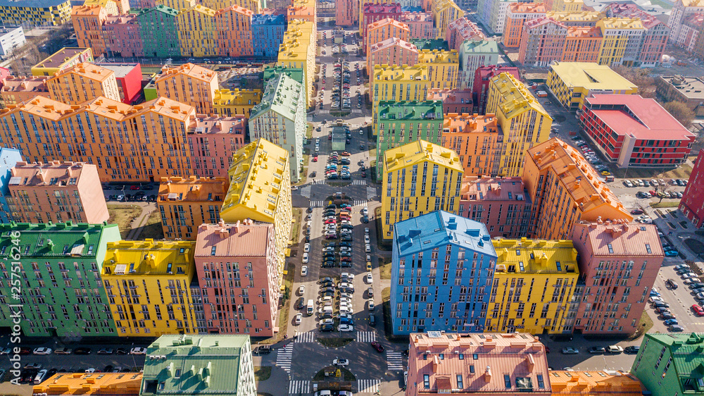 panoramic aerial view of colorful (red, green, blue, yellow) buildings on city street. drone shot - obrazy, fototapety, plakaty 