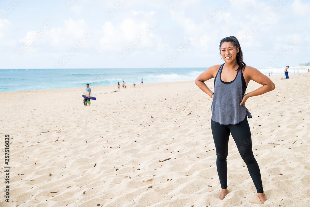 Strong young woman standing on beach on North Shore of Oahu, Hawaii, USA Strong young woman standing on beach on North Shore of Oahu, Hawaii, USA