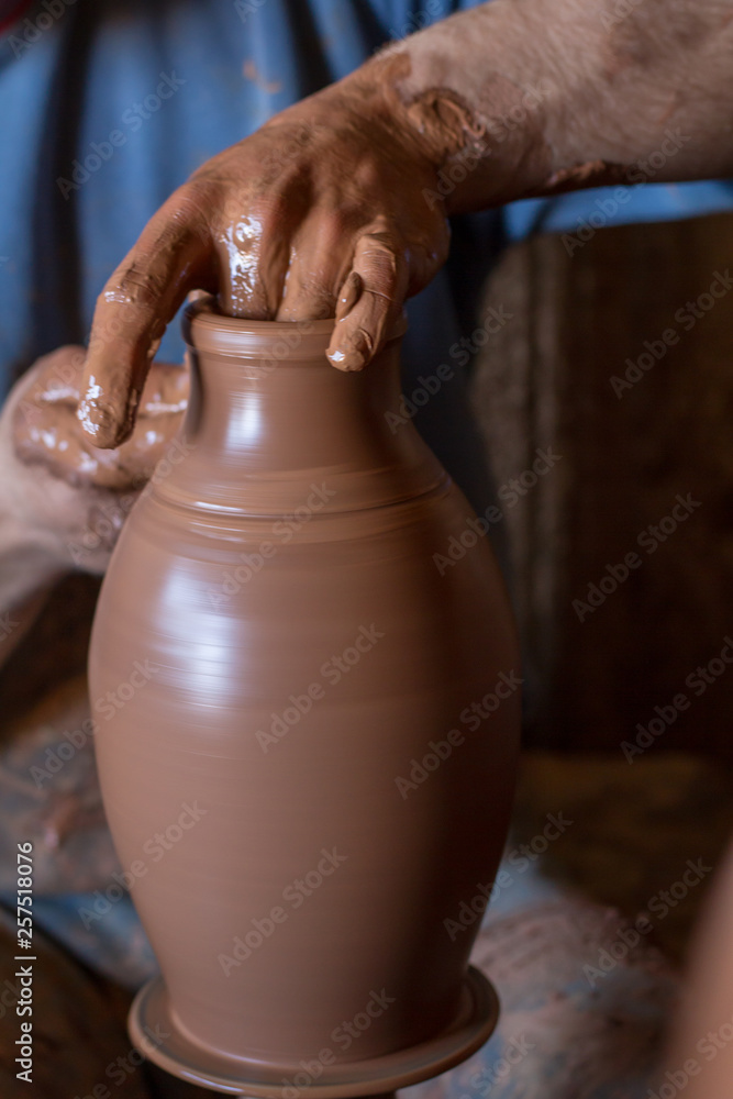 ceramic workshop - the man makes a pot of clay on a potter's wheel ceramic workshop - the man makes a pot of clay on a potter's wheel