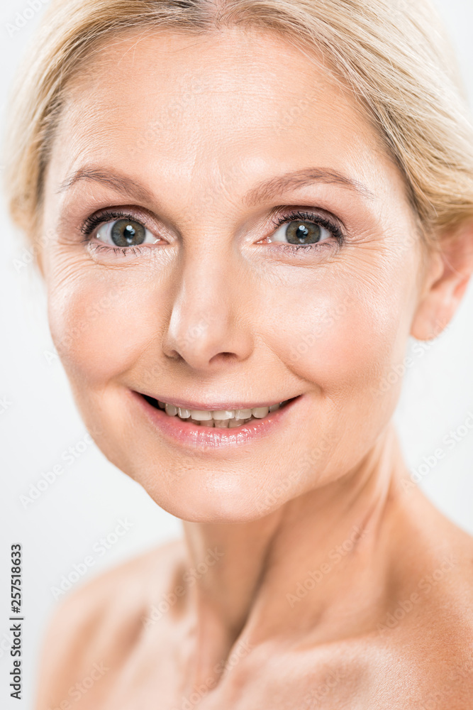 beautiful and smiling mature woman looking at camera isolated on grey beautiful and smiling mature woman looking at camera isolated on grey