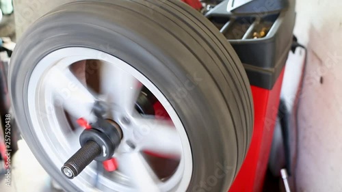 Car wheel balancing in tire service. mechanic repairman balancing automobile car wheel on balancer