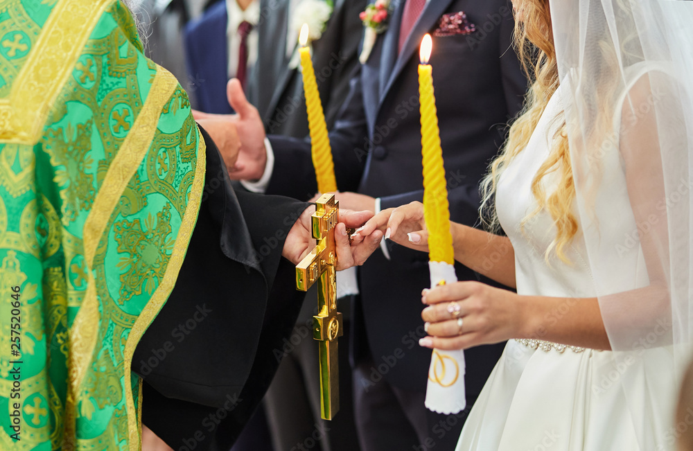 Fototapeta premium newlyweds exchange wedding rings on a ceremony in the church