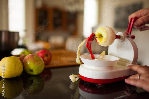 Person peeling apples with apple peeler photo