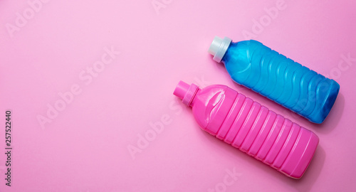 Fabric softener and detergent pink and blue color on pink background,
