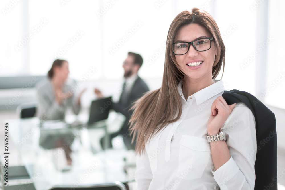 smiling business woman standing with a jacket over her shoulder smiling business woman standing with a jacket over her shoulder