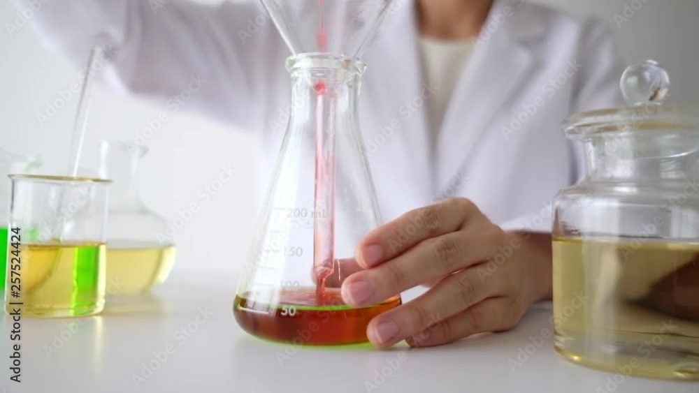 the scientist is making cosmetic in the laboratory. pour and drop the the oil by measure . natural organic essential oil . skincare product industry or homemade. bio science concept . the scientist is making cosmetic in the laboratory. pour and drop the the oil by measure . natural organic essential oil . skincare product industry or homemade. bio science concept .