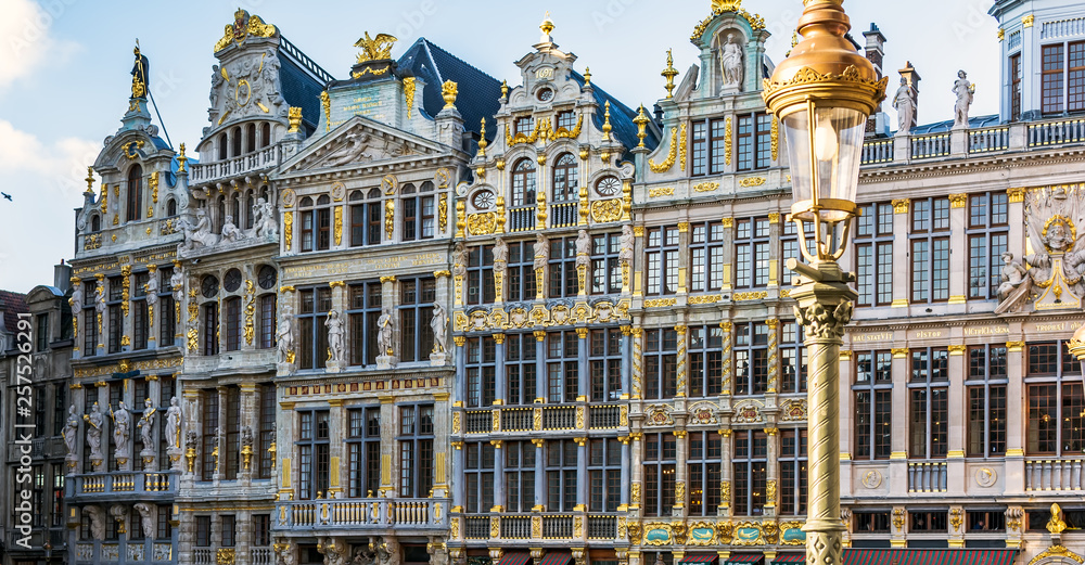 Fototapeta premium Vintage street lamp in front of rich sculptural decorated guild houses facades on The Grand Place of Brussels, Belgium. Lavishly designed gables are based on Italian Baroque with Flemish influences.