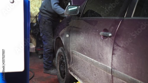 Mechanic making a diagnostic under the hood of the car in the service shop photo