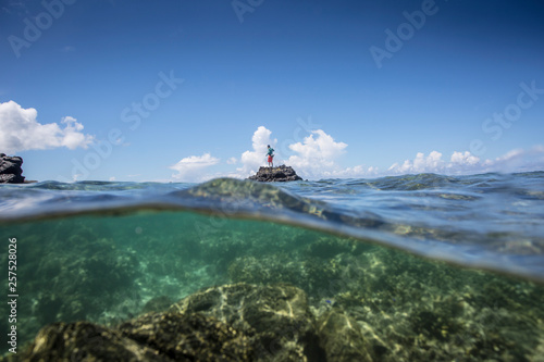 Angler Jonathan Jones stands on a reef outcropping while fly fishing inshore in Samoa.