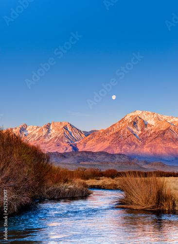 Full moon at sunrise over Eastern Sierra and Owens River, California, United States photo