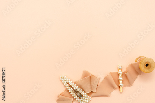 Flat lay composition with beauty trendy accessories hair pearl clip on pastel background. Top view. Copy space fot text.