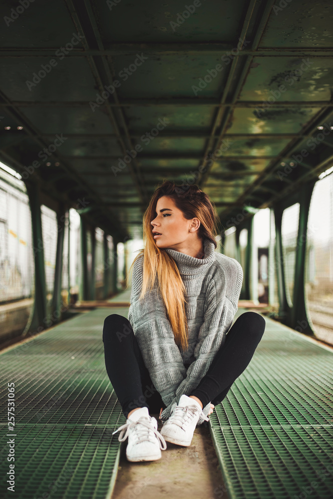 Young woman sitting in an abandoned train car Young woman sitting in an abandoned train car