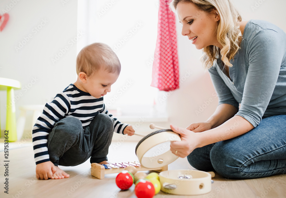 Mother and toddler son playing with musical instruments at home Mother and toddler son playing with musical instruments at home
