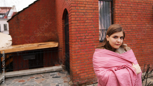  beautiful young cute girl smiling with a pink scarf near the brick house