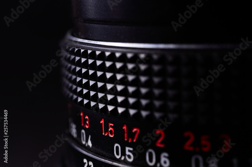 Vintage lens scale signs closeup. Stock photo with blurred gray background.