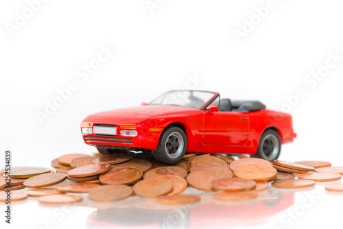 Classic of model red toy car park on stack golden coins. Saving, Financial and Installment payment concept. Isolated on white background.