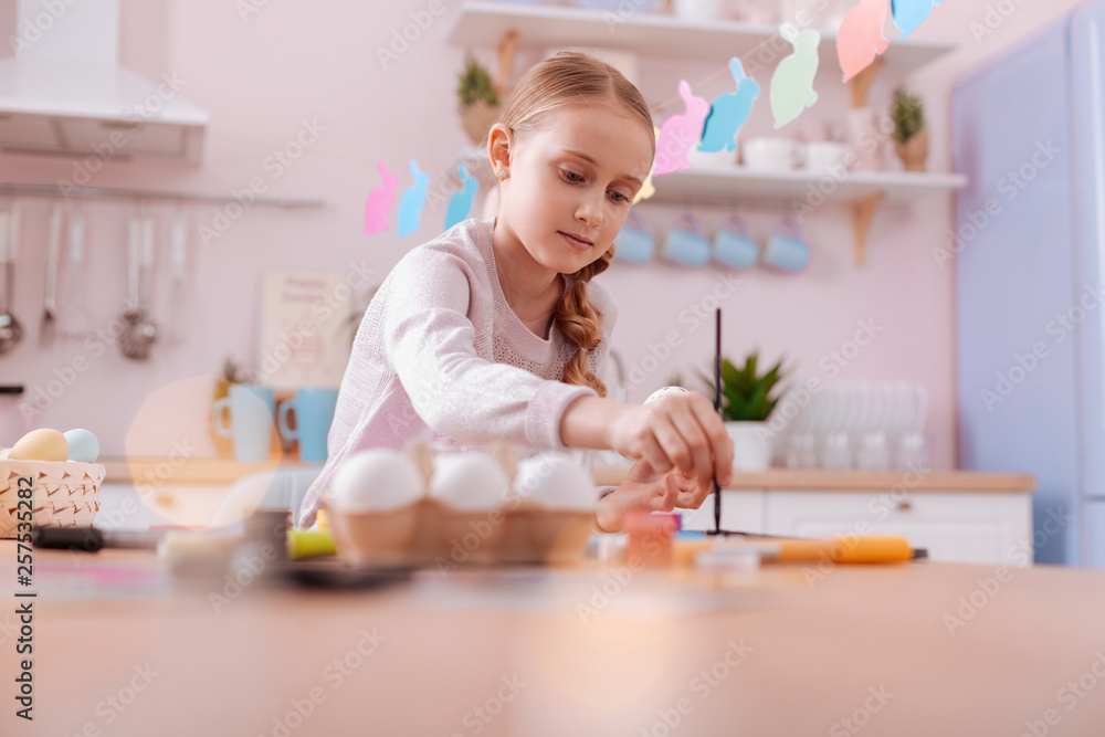 Fototapeta premium Attentive blonde girl mixing colors before painting