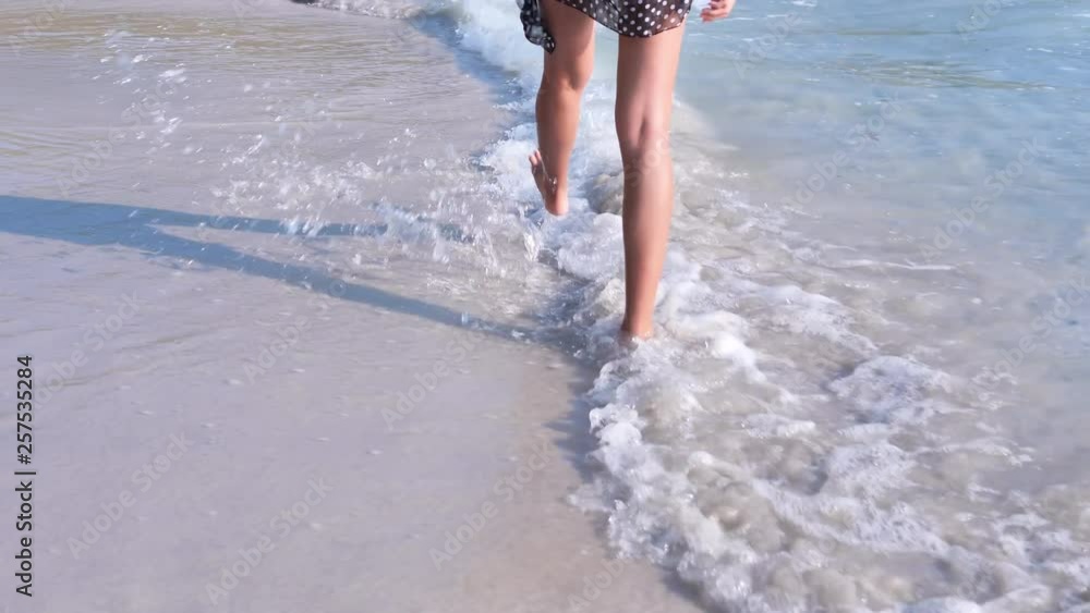 Young woman walking on the sandy beach. Concept freedom, Lifestyle, tourism, holiday. Slow Motion Young woman walking on the sandy beach. Concept freedom, Lifestyle, tourism, holiday. Slow Motion